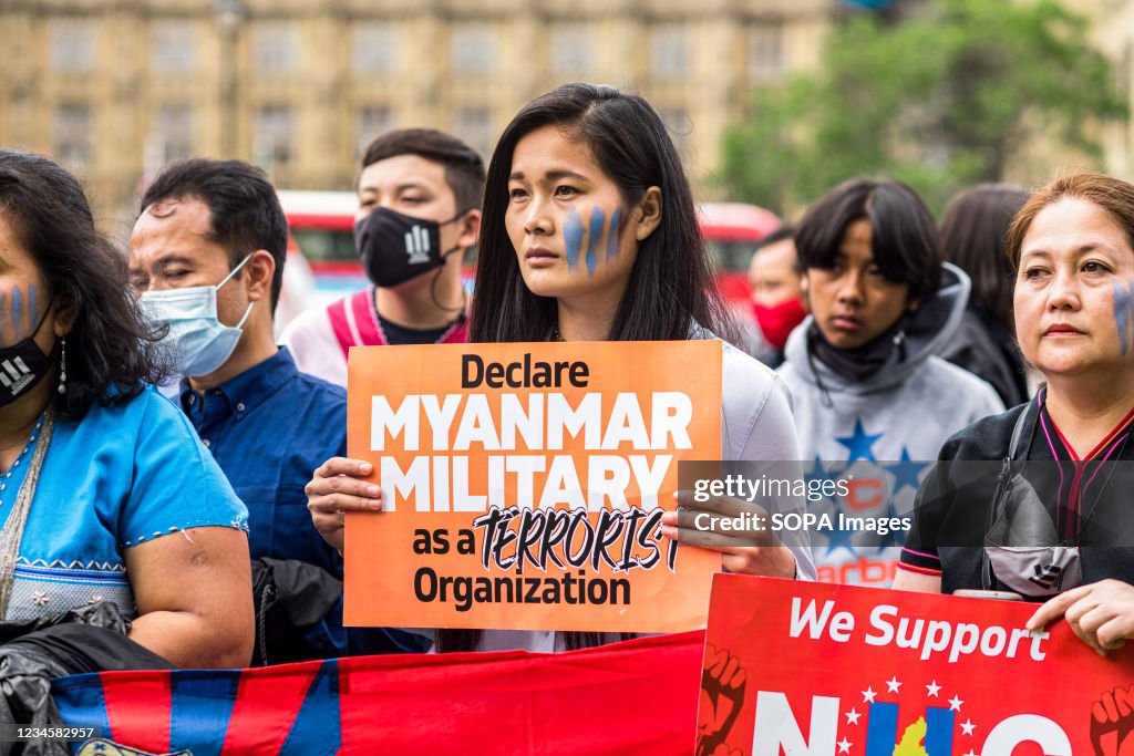 A protestor holds a placard that says Declare military as a...