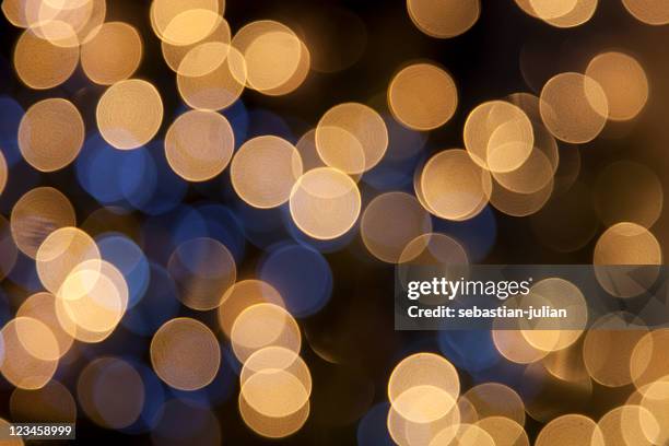 defocused golden light dots against black background - christmas background abstract gold stock pictures, royalty-free photos & images