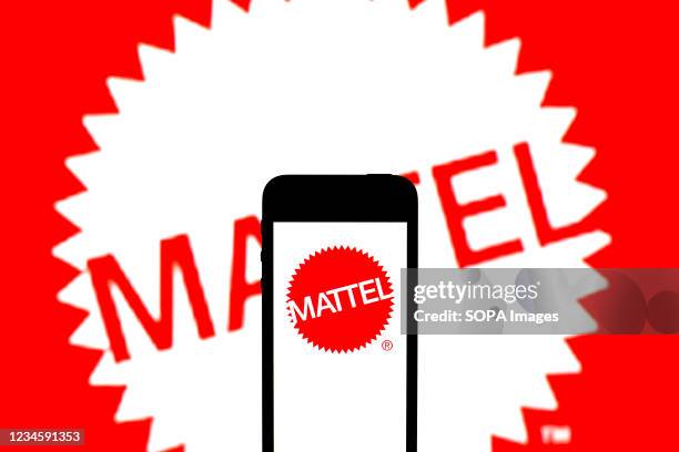 In this photo illustration, a Mattel Inc. Logo seen displayed on a smartphone and in the background.