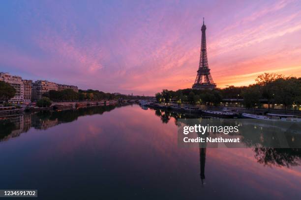 scenic view of eiffel tower over seine river during dramatic sunset, paris, france - paris skyline sunset stock pictures, royalty-free photos & images