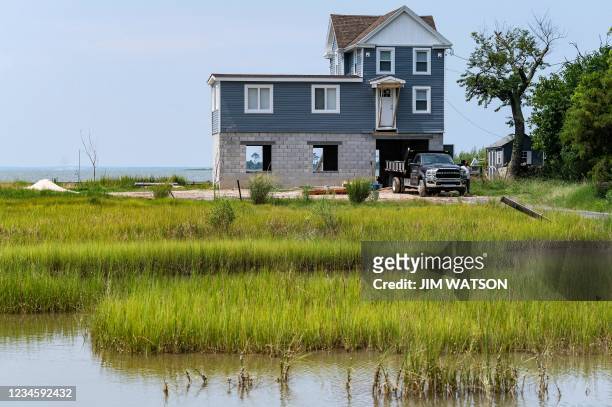 Home is raised onto a newly constructed foundation to remove it from rising water levels on Hoopers Island, Maryland on August 9 where the evidence...