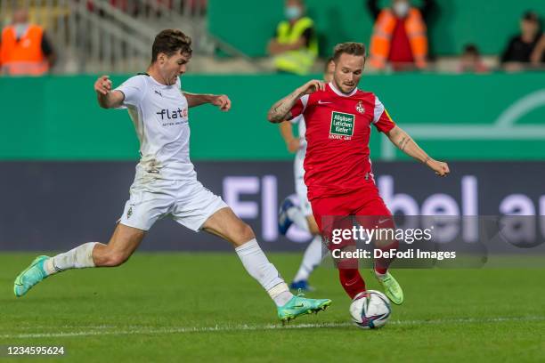 Joseph Michael Scally of Borussia Moenchengladbach and Marius Kleinsorge of 1. FC Kaiserslautern battle for the ball during the DFB Cup first round...