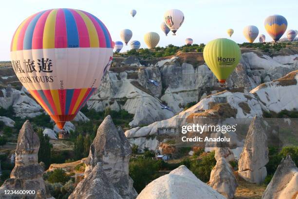 Hot air balloons glide over historical Cappadocia region, located in Nevsehir province of Turkey on August 10, 2021. A total of 138,225 tourists...