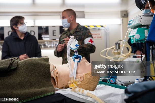 Defence Minister Annegret Kramp-Karrenbauer listens to explanations as she stands next to a dummy in a so-called shock room of a mobile rescue centre...