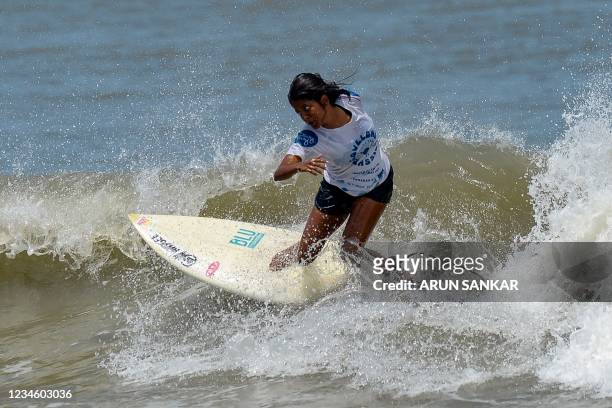 Woman surfs during the annual Covelong Point Classic Surf festival at Kovalam on the outskirts of Chennai on August 10, 2021.