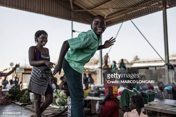 Children dance on top of market counters as representatives of the Zambian opposition party United Party for National Development of the presidential...