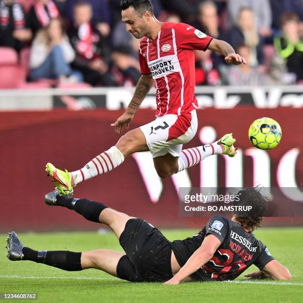 Eindhoven's Israeli forward Eran Zahavi jumps over FC Midtjylland's Danish defender Rasmus Nicolaisen during the UEFA Champions League third...
