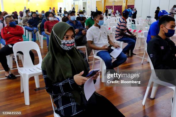 Members of the public wait in an observation area after receiving the Sinovac Biotech Covid-19 vaccine at a vaccination center set up at the PKNS...