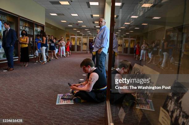 People wait in line to speak in person at the Loudoun County school board meting on August 10, 2021 in Ashburn, Va. The Loudoun school board will...