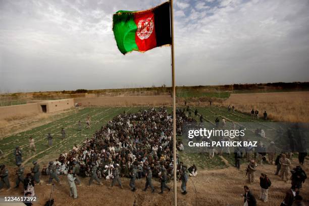 The Afghan national flag is hoisted during an official flag raising ceremony in Marjah on February 25, 2010. The Afghan flag was raised over a town...