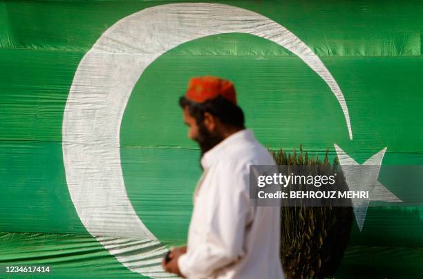 Pakistani Muslim walks past his national flag after performing congregational Friday prayers at the Faisal Mosque in Islamabad on January 1, 2010....