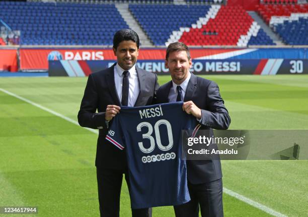 Lionel Messi and Nasser Al-Khelaifi, CEO of Paris Saint-Germain football club, pose on the pitch of the Parc des Princes after holding a press...