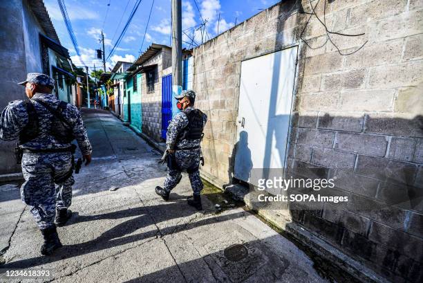 Police officers patrol the community during a search operation for gang members. El Salvador's National Police performs police operations at the...