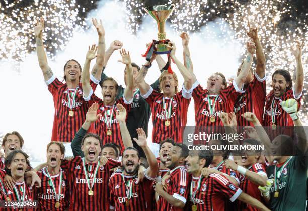 Milan players hold the Scudetto trophy after winning the Italian football Serie A title on May 14, 2011 at San Siro stadium Milan. AC Milan claimed...