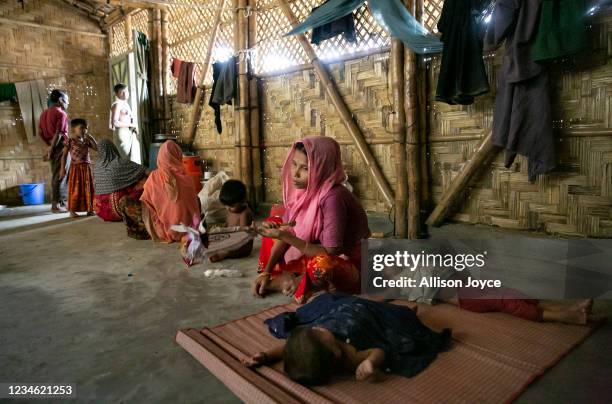 Romiza Begum fans her children in a Rohingya refugee camp on August 11, 2021 in Cox's Bazar, Bangladesh. Begum is now sharing a temporary shelter...