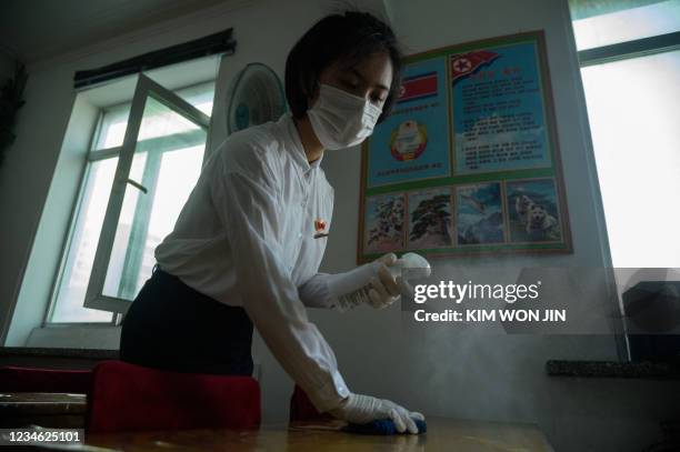 Student of the Pyongyang Jang Chol Gu University of Commerce sprays disinfectant in a classroom as part of preventative measures against Covid-19, in...