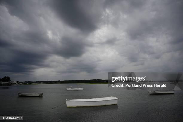 Dinghies in the Nonesuch River in Scarborough tied to their moorings as dark clouds roll overhead before the rain started to fall Thursday, July 29,...