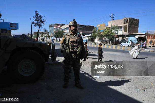 An Afghan security force personnel stands guard along the roadside in Herat on August 12 as Taliban took over the police headquarters in Herat,...