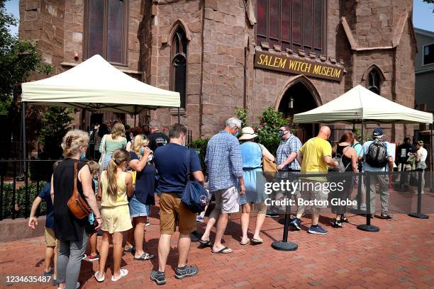 Salem, MA People line up and put on masks as they prepare to enter the Salem Witch Museum in Salem, MA on August 11, 2021. Salem has mandated that...