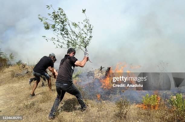 Smokes and flames rise from the wildfire as ground and aerial extinguishing operations continue in Tizi Ouzou, at Beni Douala town of Algeria on...