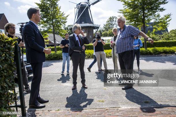 Outgoing Prime Minister Mark Rutte and acting mayor Gerard Beukema are approached by a victim of the reinforcement operation during a walk after a...