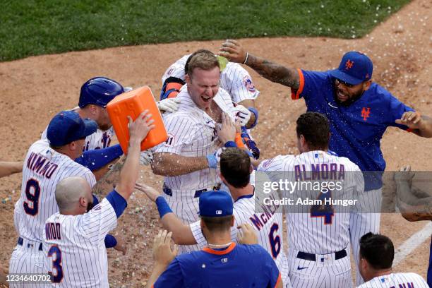 Pete Alonso of the New York Mets is congratulated by teammates after hitting a walk-off home run to defeat the Washington Nationals in game two of a...