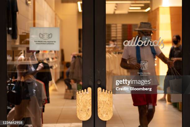 Shopper walks past a sign requiring masks at an Allbirds Inc. Store in Philadelphia, Pennsylvania, U.S., on Thursday, Aug. 12, 2021. The City of...