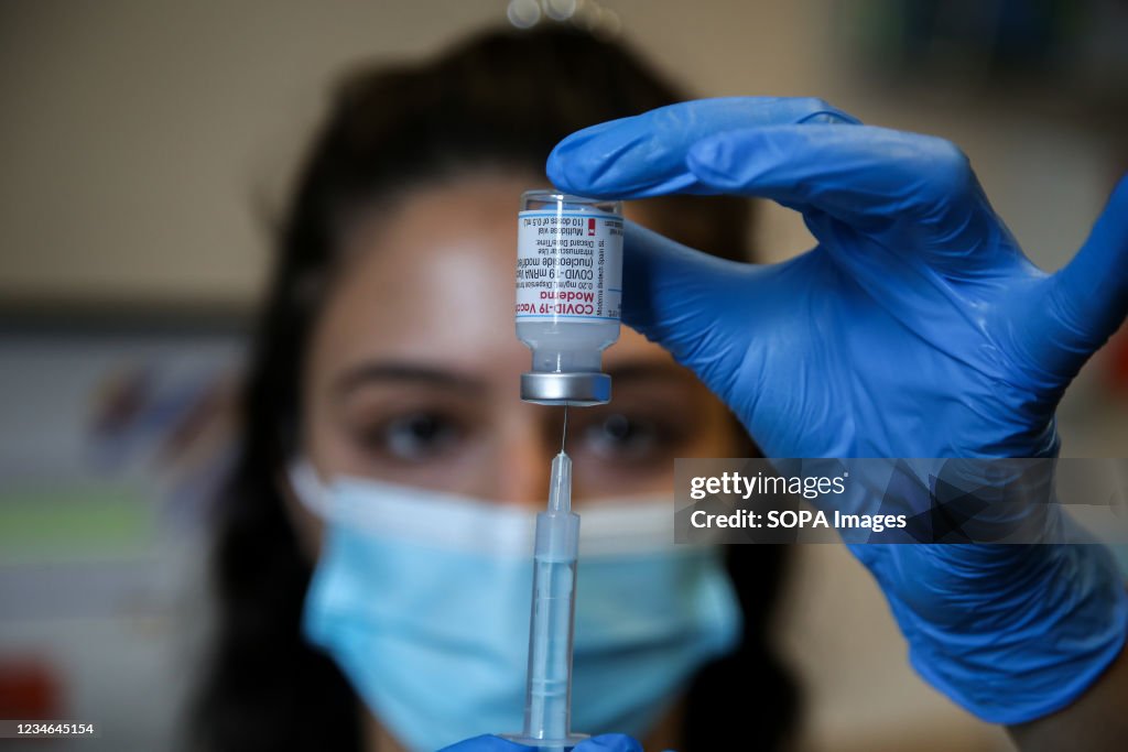 A NHS vaccinator prepares to administer the Moderna Covid-19...