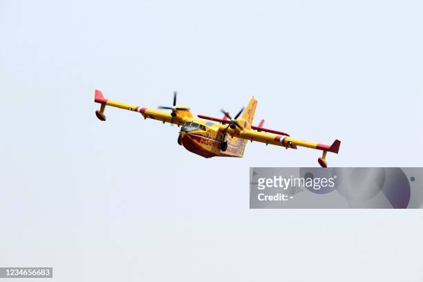 French firefighting plane restocks with water off the coast of the city of Bejaia, some 220 km east of the capital Algiers, as they help fight forest...