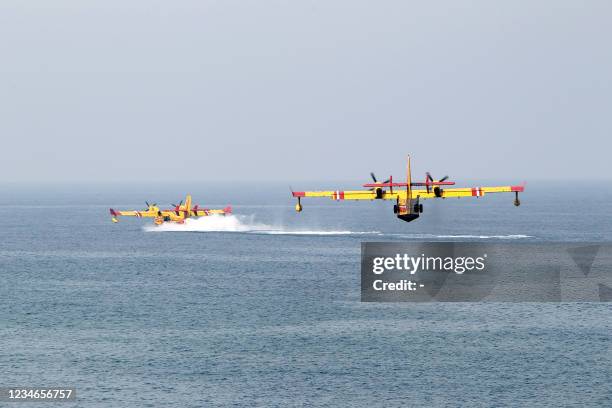 French firefighting planes restock with water off the coast of the city of Bejaia, some 220 km east of the capital Algiers, as they help fight forest...