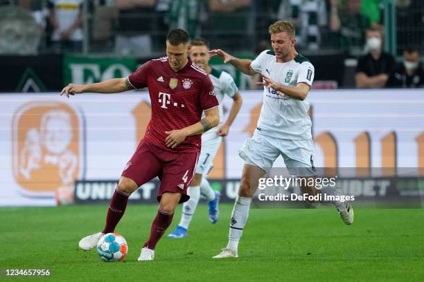 Niklas Suele of Bayern Muenchen, Christoph Kramer of Borussia Moenchengladbach battle for the ball during the Bundesliga match between Borussia...