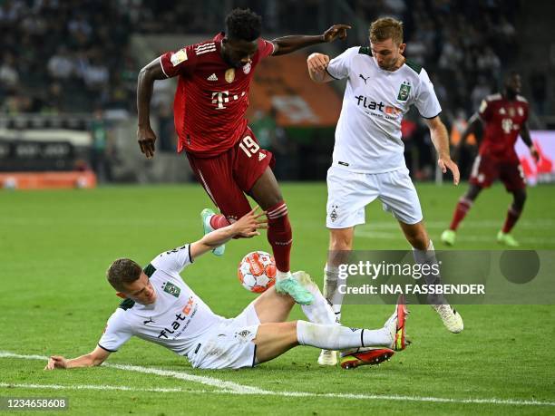 Moenchengladbach's German midfielder Christoph Kramer watches as Bayern Munich's Canadian midfielder Alphonso Davies steps on the leg of...