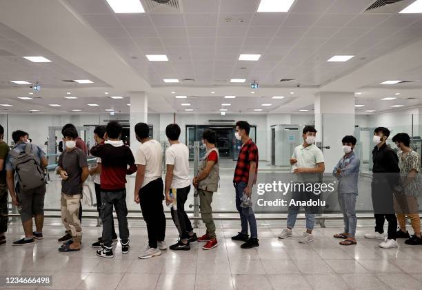 Afghan irregular migrants, taken to the repatriation centre for procedures, are seen at Istanbul Airport to be deported in Istanbul, Turkey on August...