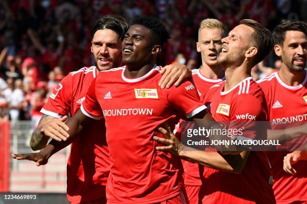 Union Berlin's Nigerian forward Taiwo Awoniyi is celebrated by teammates after scoring the team's first goal during the German first division...
