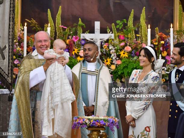 Bishop Johan Dalman holds up Prince Julian as he poses beside Reverend Michael Bjerkhagen, Princess Sofia and Prince Carl Philip during the...