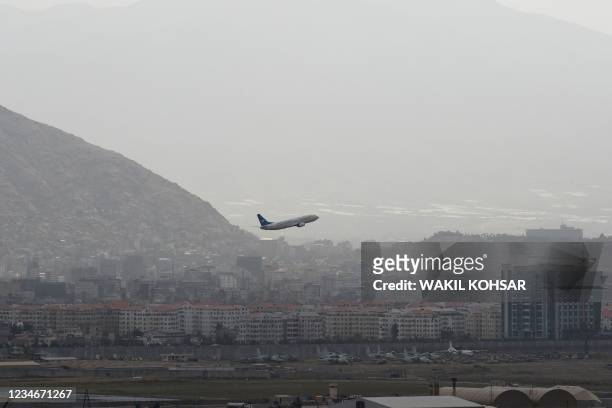 This picture taken on August 14, 2021 shows an Ariana Afghan Airlines aircraft taking-off from the airport in Kabul.