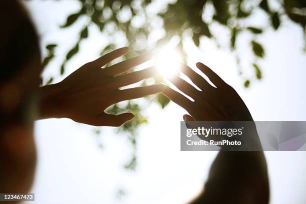 young woman cupping hands around sun - hands happy ストックフォトと画像