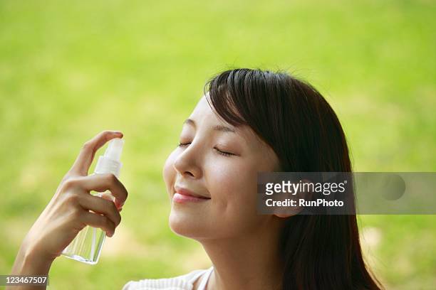 young woman spraying water on face - perfume japan stock pictures, royalty-free photos & images