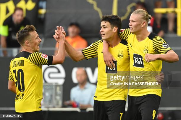 Dortmund's US midfielder Giovanni Reyna celebrates after scoring the 4-1 goal with Dortmund's Norwegian forward Erling Braut Haaland and Dortmund's...