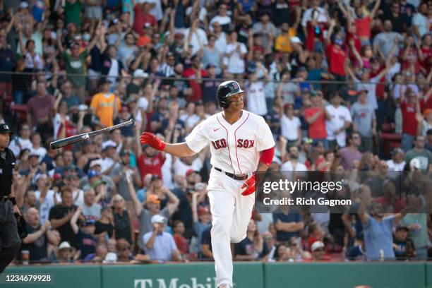 Rafael Devers of the Boston Red Sox slips his bat after hitting a home run against the Baltimore Orioles during the first inning at Fenway Park on...