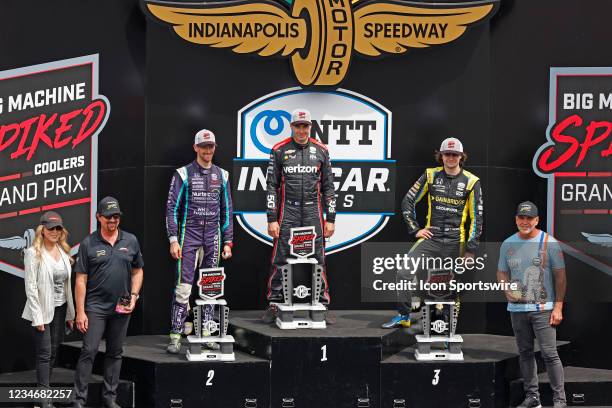 Indy Car series driver Will Power poses for photos on the podium with 2nd place finisher Romain Grosjean and third place finisher Colton Herta after...