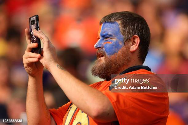 Denver Broncos fan takes a photo on his cell phone in the fourth quarter of preseason play against the Minnesota Vikings at U.S. Bank Stadium on...