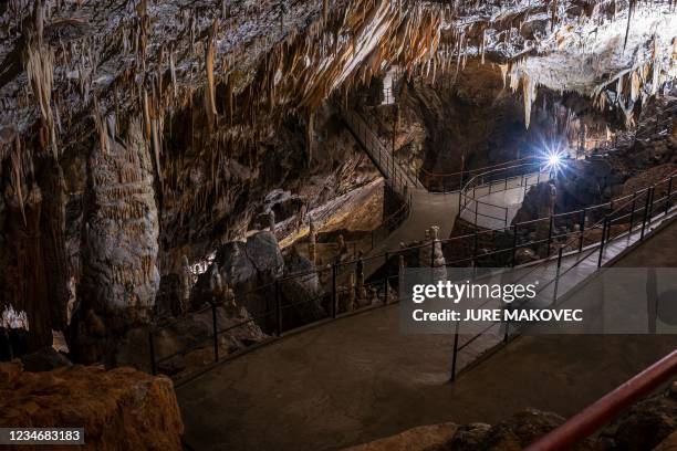 This photograph taken on May 25, 2021 shows stalagmites, stalactites and other cave formations in a part of the Postojna Cave in Postojna. - The...