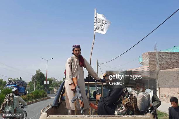 Taliban fighters drive an Afghan National Army vehicle through the streets of Laghman province on August 15, 2021.