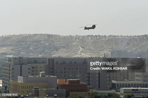 Chinook military helicopter flies above the US embassy in Kabul on August 15, 2021. Several hundred employees of the US embassy in Kabul have been...