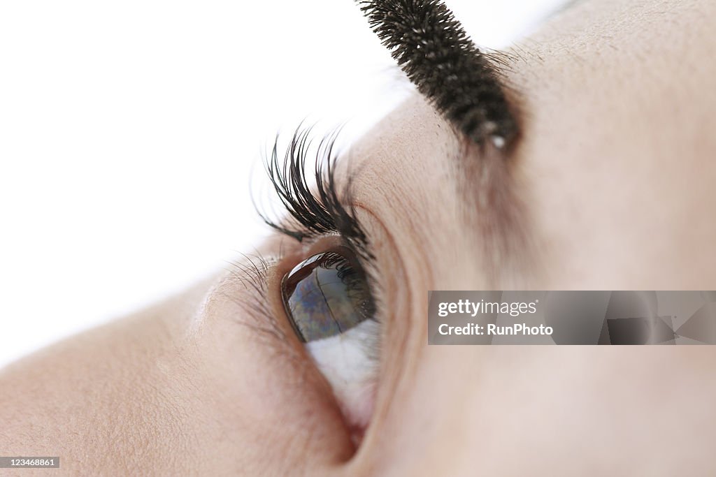 Young woman applying eyebrow mascara,close-up