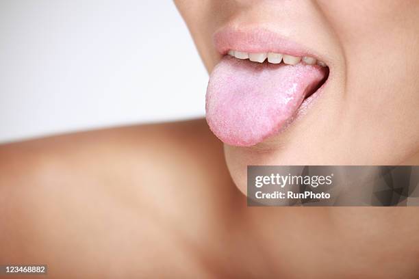 young woman sticking out tongue, close-up - human tongue foto e immagini stock
