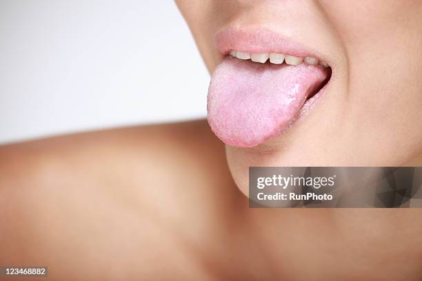 young woman sticking out tongue, close-up - mensentong stockfoto's en -beelden