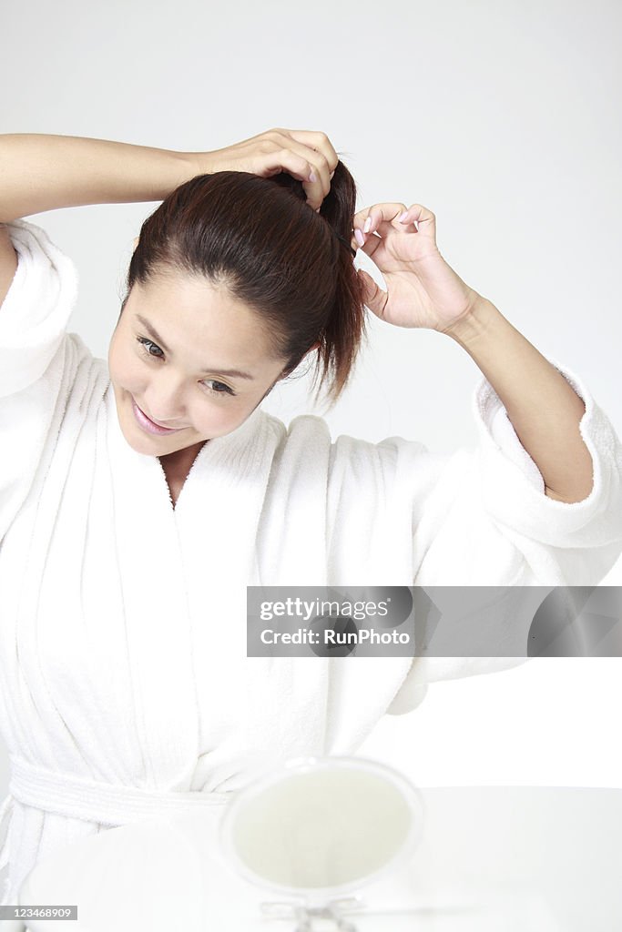 Young woman putting her hair up and smiling