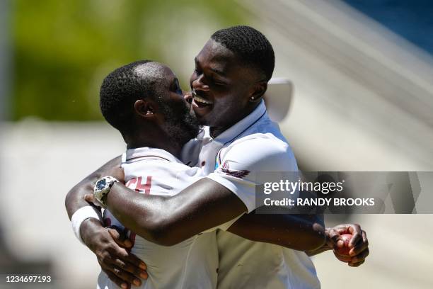 Kemar Roach and Jayden Seales of West Indies hug in celebration after dismissing Hasan Ali of Pakistan during day 4 of the 1st Test between West...